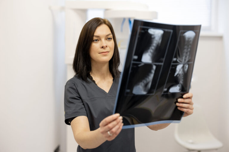 Person holding cervical spine X-ray.