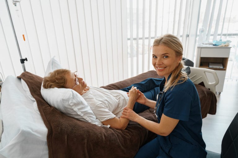 Therapist comforting patient in bed.