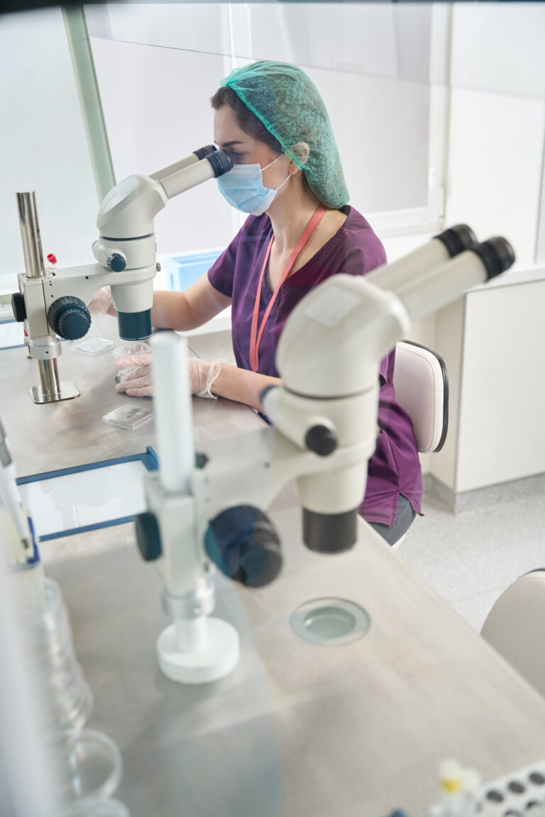 Scientist using microscope in laboratory.