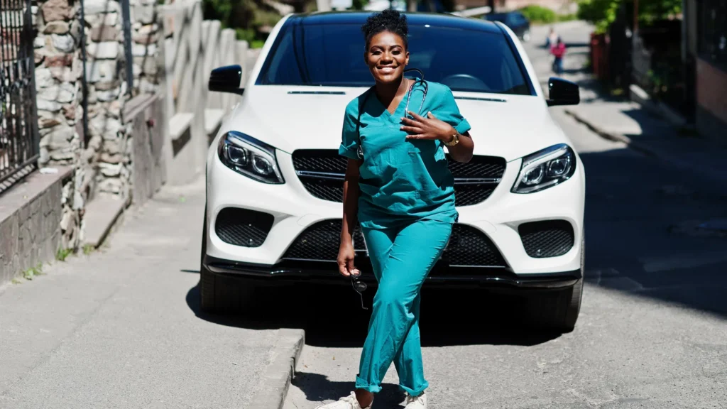Female nurse standing in front of white SUV.