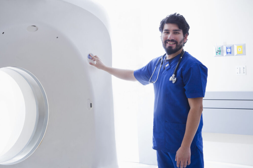 Medical professional near CT scanner.